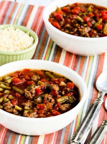 Square image for Instant Pot Soup with Ground Beef, Green Beans, and Tomatoes shown on napkin with spoons and Parmesan.