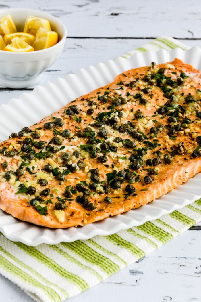 Slow Cooked Salmon with butter, garlic, capers, and lemon on serving plate