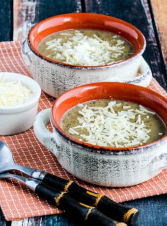 Instant Pot Cauliflower Mushroom Soup shown in two bowls with spoons and Parmesan.
