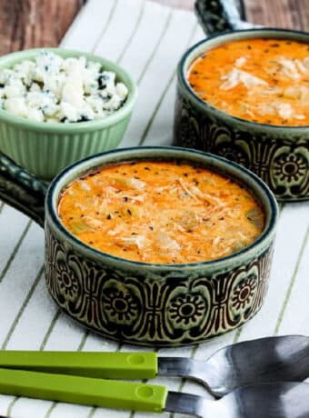 Instant Pot Buffalo Chicken Soup shown in two bowls with spoons and crumbled blue cheese.