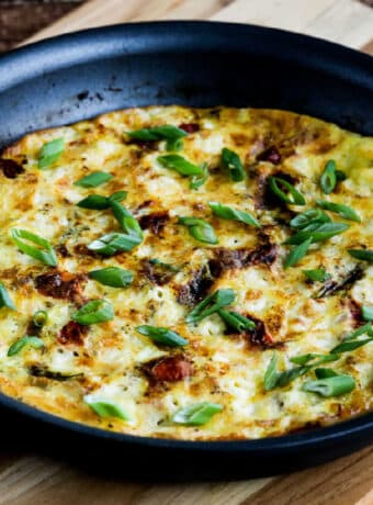 Square image for Asparagus Tomato Frittata shown in pan on cutting board.