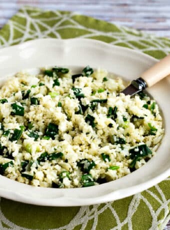 Square image for Easy Cauliflower Rice Recipe shown in serving bowl with spoon, or green-white napkin.