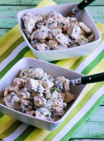 Square image of Chicken Salad with Basil shown in two serving bowls on striped napkin.
