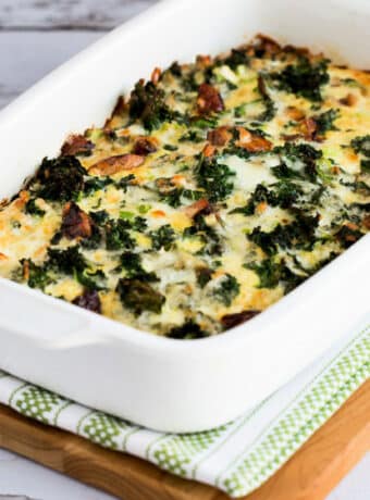 Square image for Sausage, Kale, and Mozzarella Egg Bake shown in baking dish on napkin and cutting board.