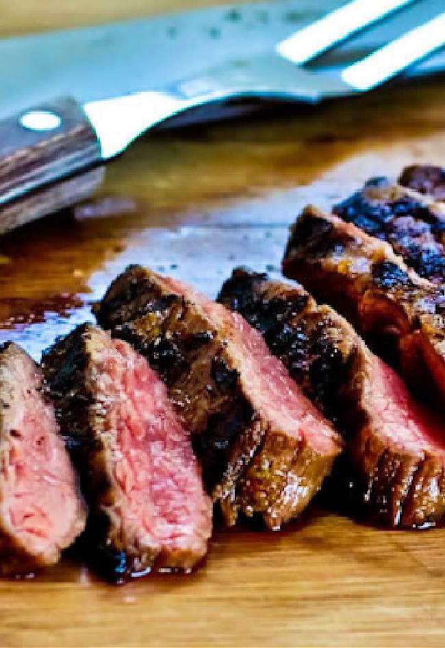Cuban Flank Steak sliced on cutting board.