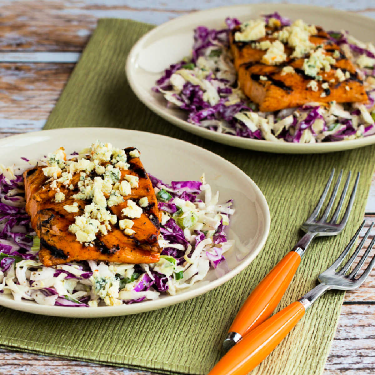 Buffalo Salmon with Blue Cheese Slaw shown on two serving plates.