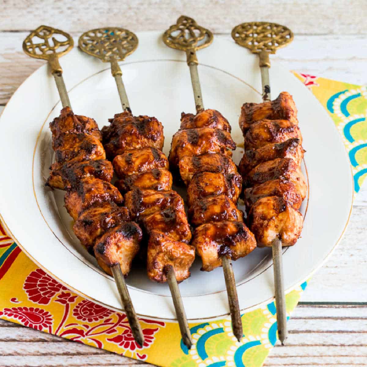 Grilled Sriracha Chicken Kabobs with four kabobs shown on serving plate.