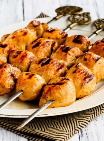 Square image of Asian Marinated Chicken Kabobs shown on serving platter.