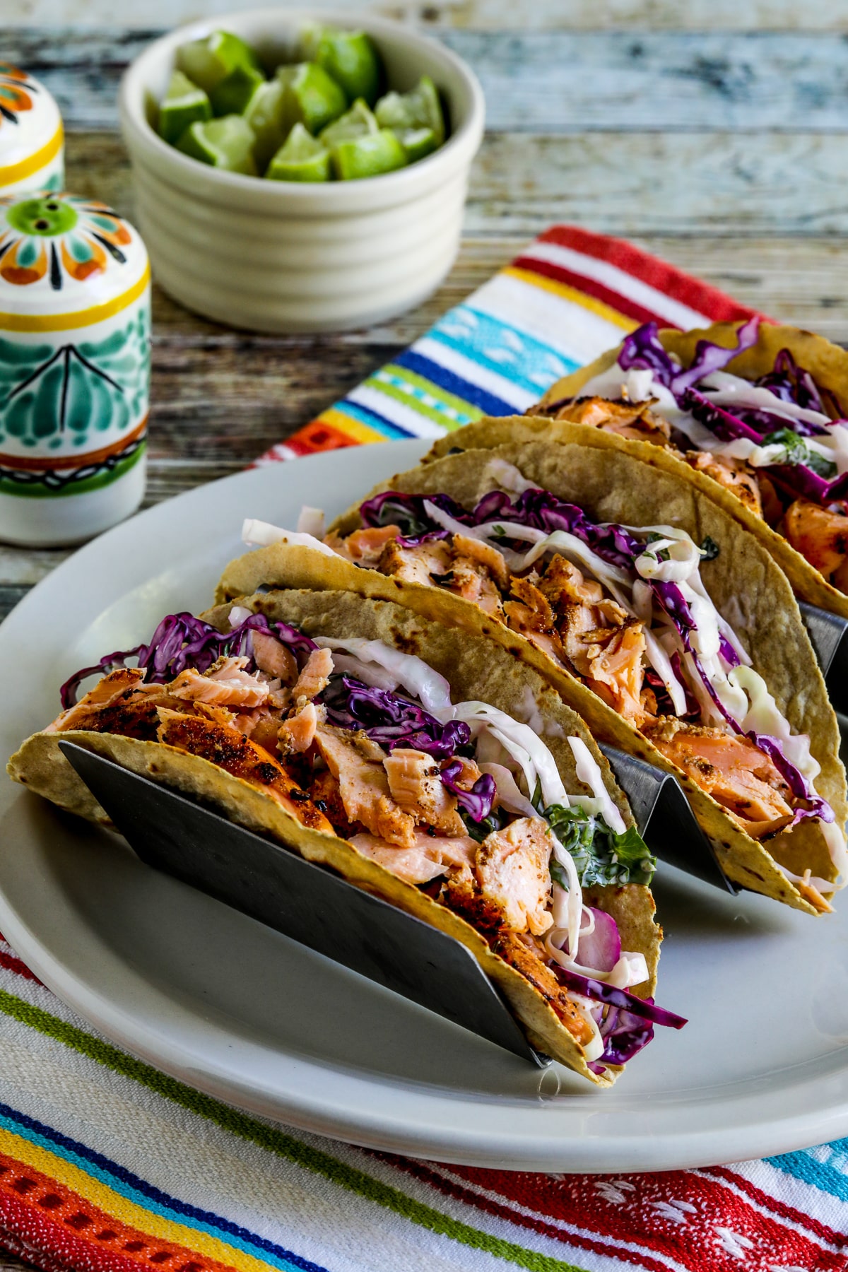 Salmon taco with Mexican slaw in a taco stand on the plate