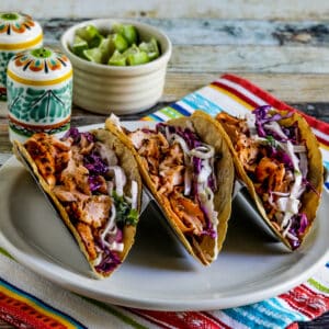 square image of Salmon Tacos with Mexican Slaw in taco holder on plate