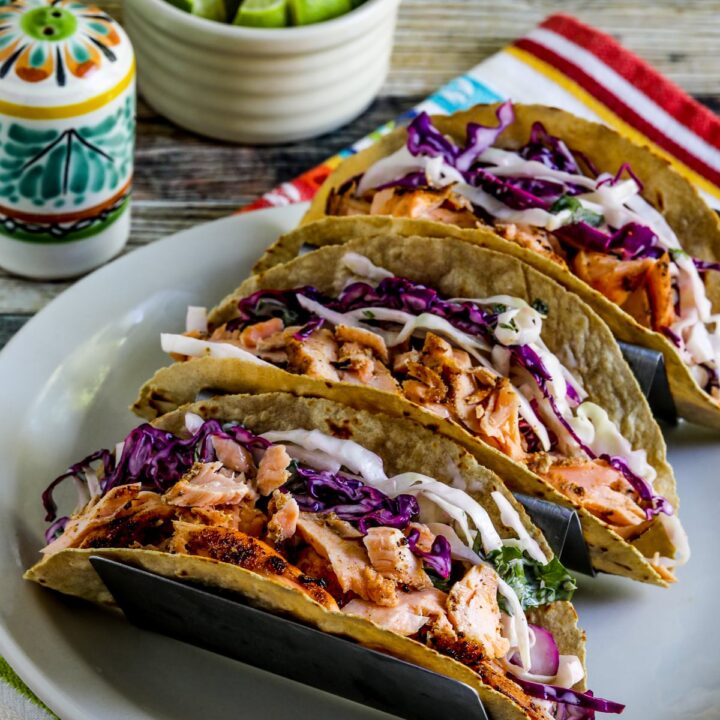 Salmon Tacos with Mexican Slaw shown in taco holder with limes on the side