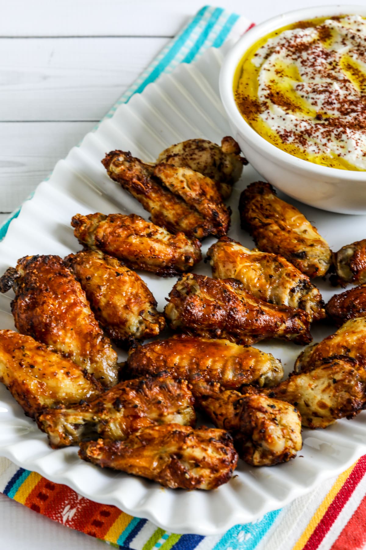 Greek air fryer chicken wings served on a platter with feta cheese dip