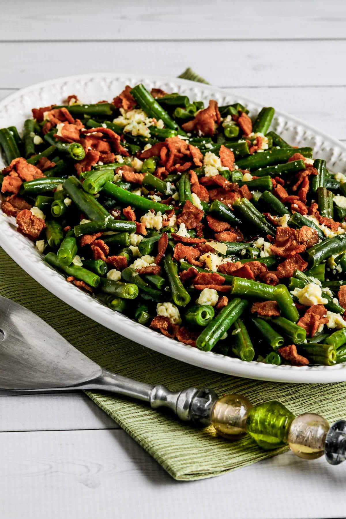 Instant green beans with bacon and gorgonzola on serving plate on a green napkin