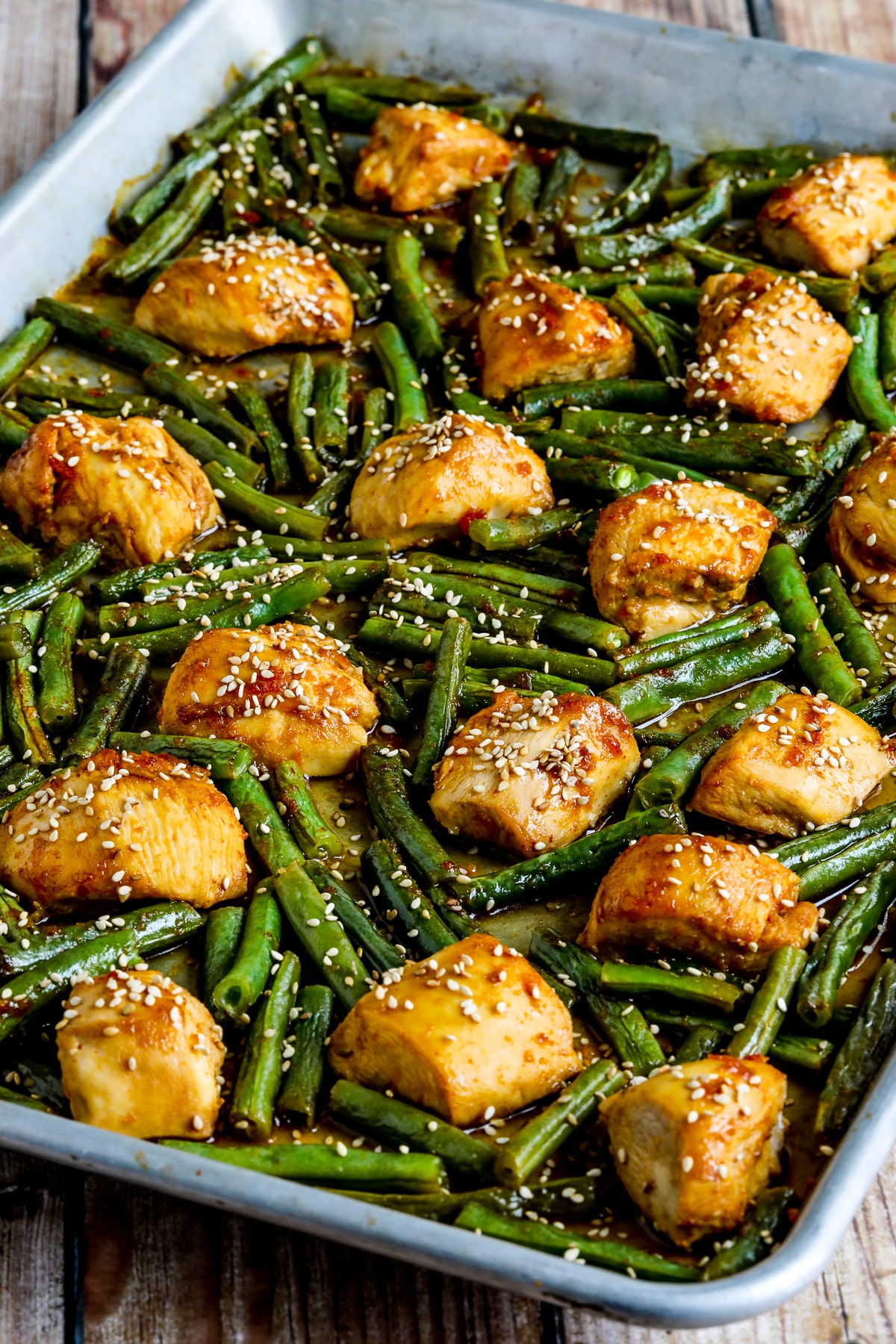 Asian Chicken and Green Beans Sheet Pan Meal shown on sheet pan with sesame seeds.