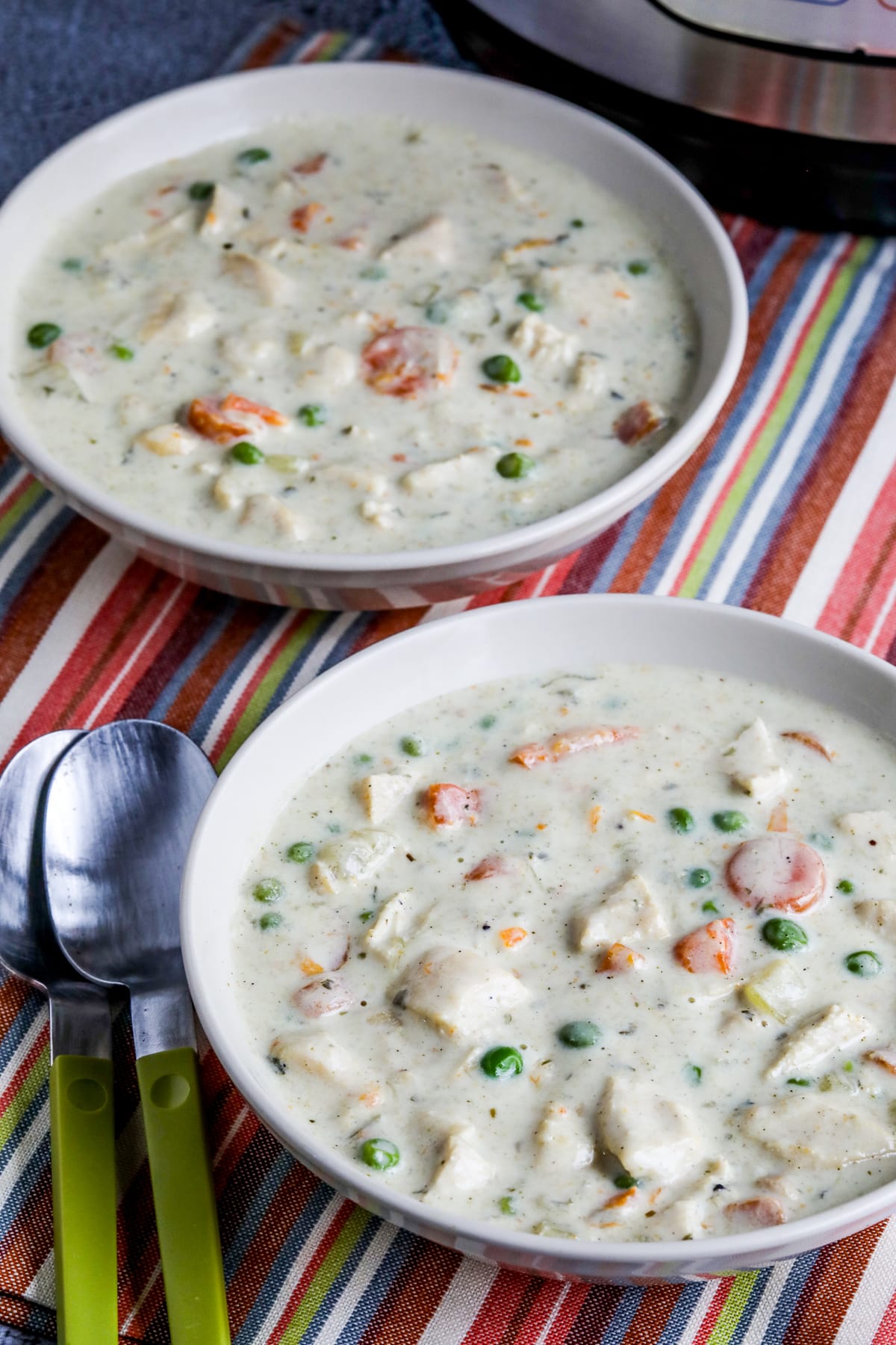 Instant Pot Chicken Pot Pie Soup shown in two serving bowls with Instant Pot in back.