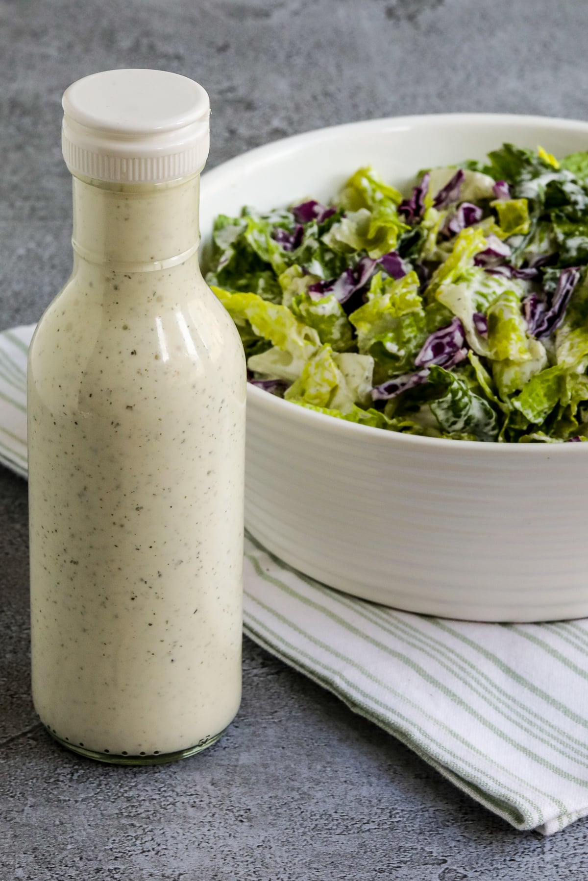 BYU Creamery Ranch Dressing (Copycat Recipe) shown in bottle with salad with Ranch on the side.