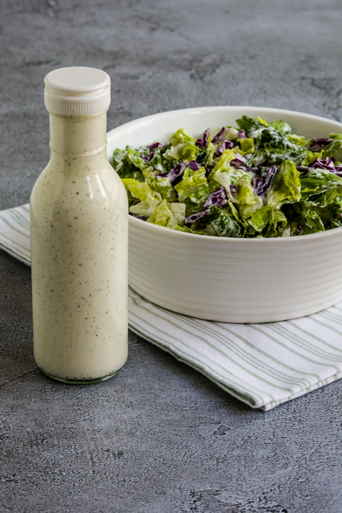 BYU Creamery Ranch Dressing (Copycat Recipe) shown with bottle of salad dressing and bowl of salad.