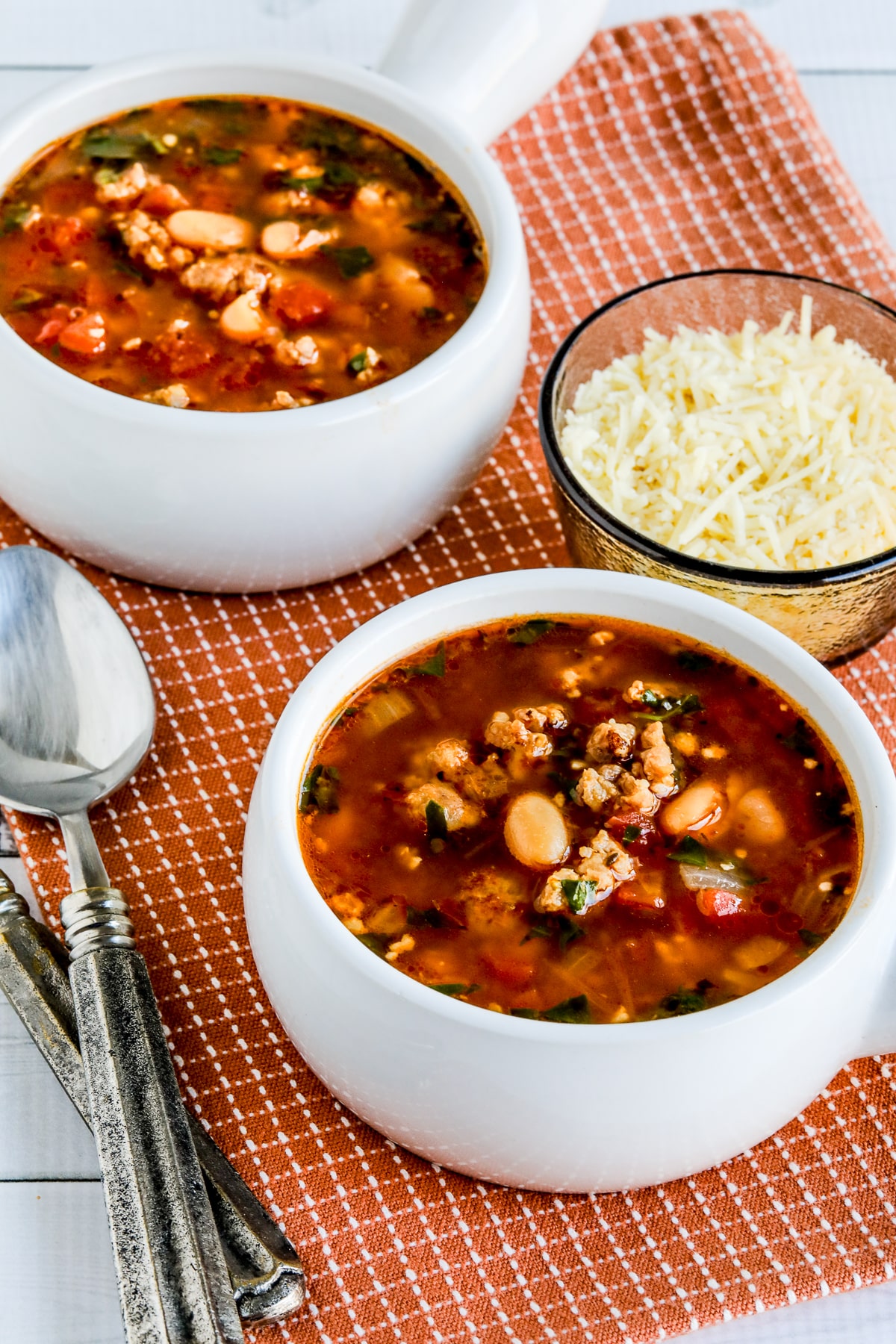 Cannellini Bean and Sausage Soup show in two bowls with Parmesan Cheese.