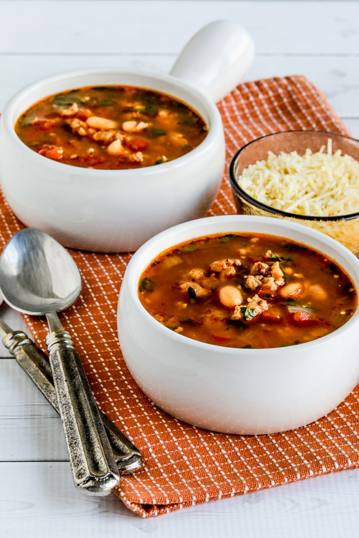 Cannellini Bean and Sausage Soup in two bowls, less close-up image.