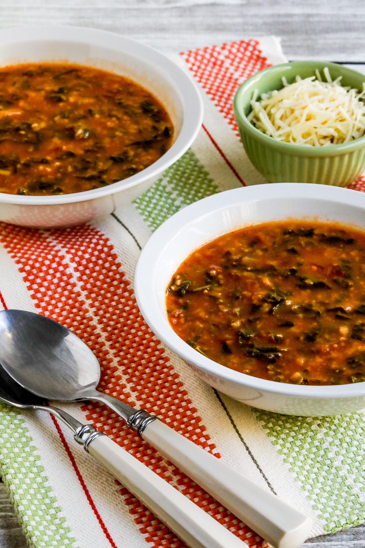 Less close-up photo of Tomato Spinach Soup in two bowls.